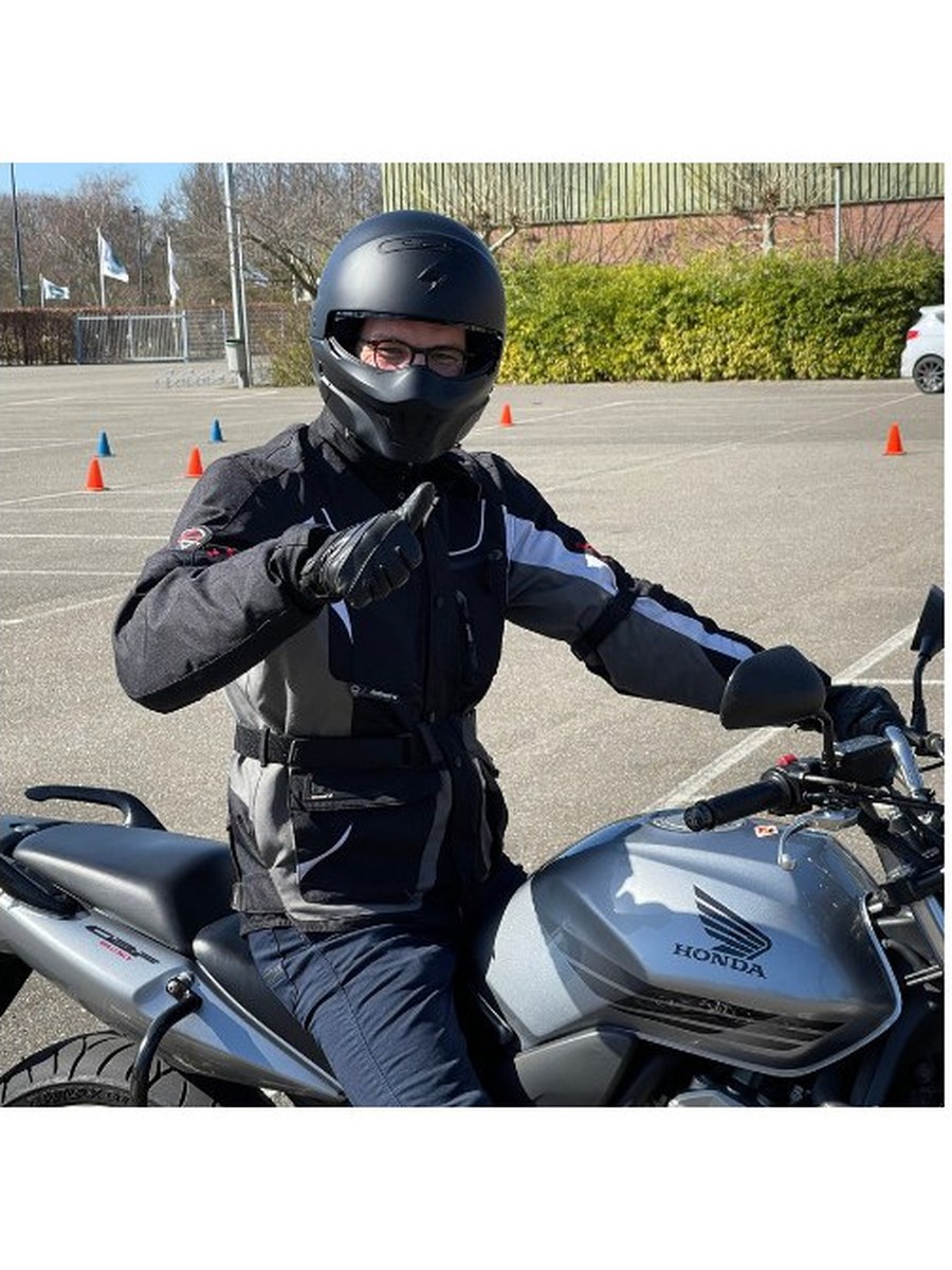 Motorleerling oefent op het oefenterrein met pilonnen